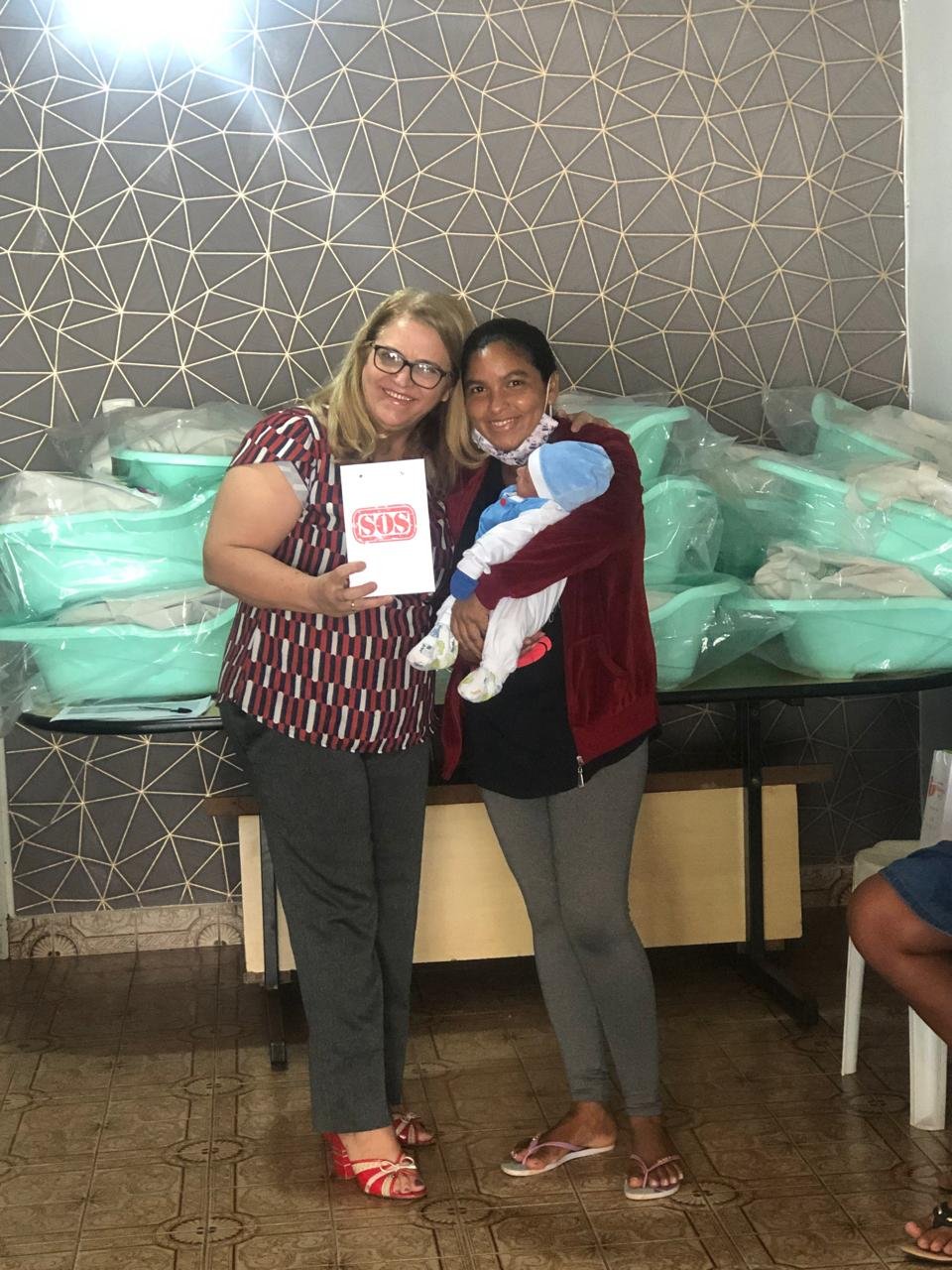 Entrega de enxoval para mãe acompanhada de seu bebê